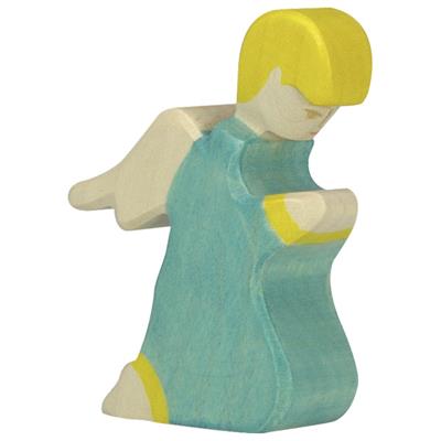 Wooden figurine of a girl in a blue dress with yellow accents on a white background