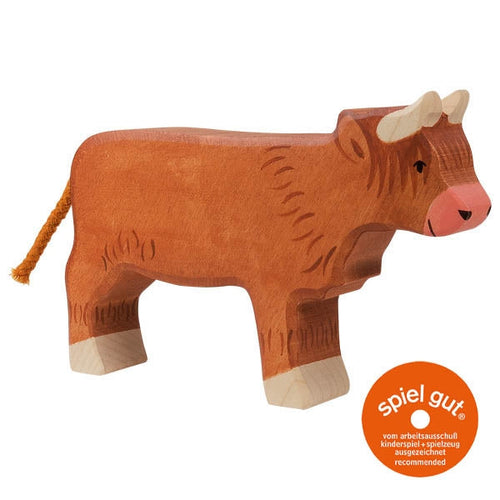 Wooden cow toy with 'spiel gut' certification logo on a white background