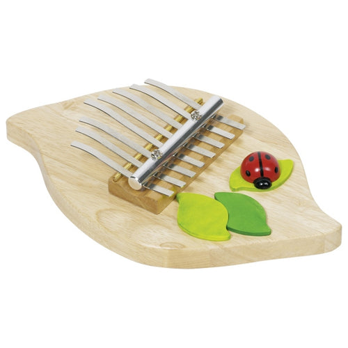 Wooden kalimba with ladybug and leaves on a white background