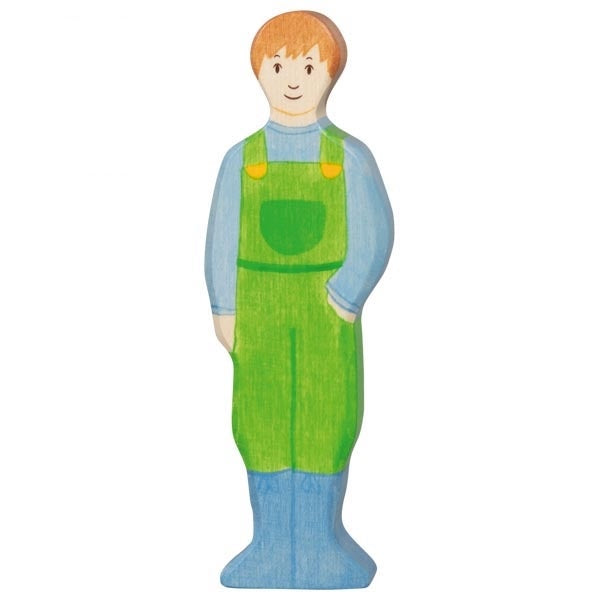 Wooden toy figure of a man wearing green overalls on a white background