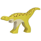 A wooden figure of a yellow Staurikosaurus dinosaur with brown spots, handcrafted and painted with natural dyes.